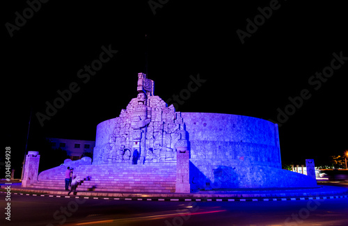 Tourist taking photos of the Monument to the Fatherland at night, Yucatan, Mexico. Patria Monument in Paseo de Montejo. Merida photo