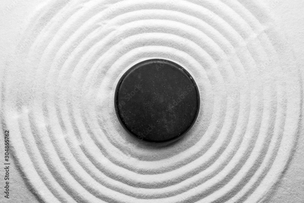 Black stone on sand with pattern, top view. Zen, meditation, harmony - obrazy, fototapety, plakaty 