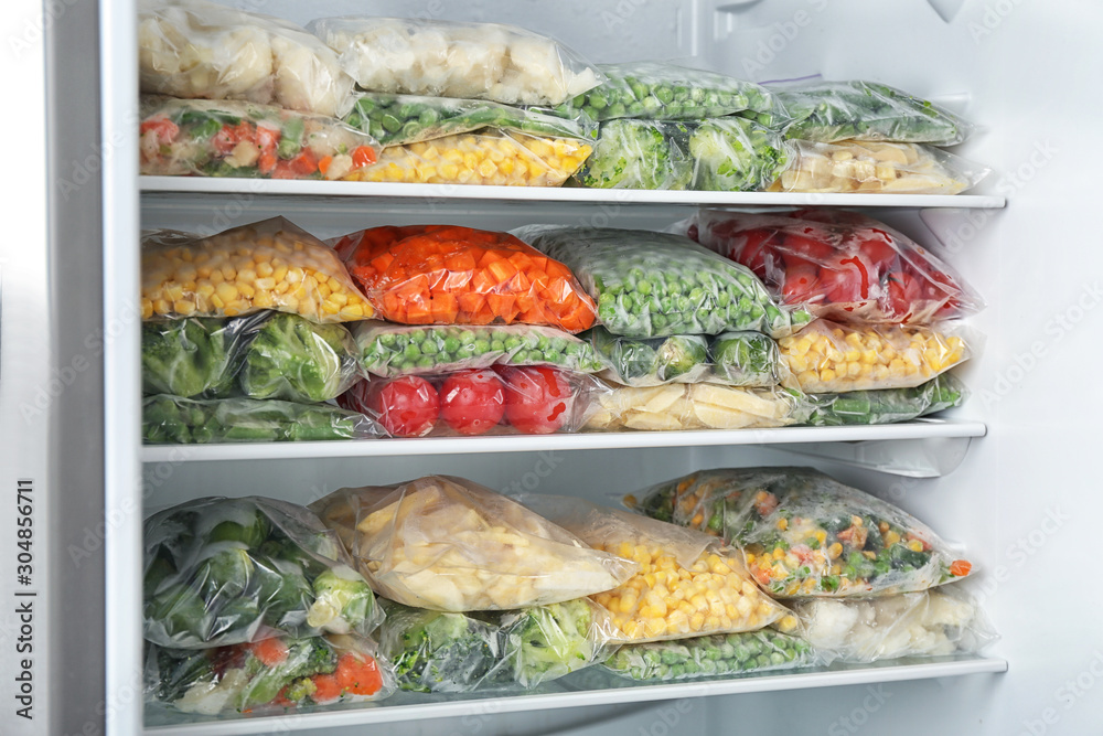 Plastic bags with different frozen vegetables in refrigerator Plastic bags with different frozen vegetables in refrigerator