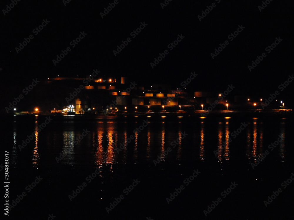 A breathtaking view of a summer night with street and house lights on a small island.