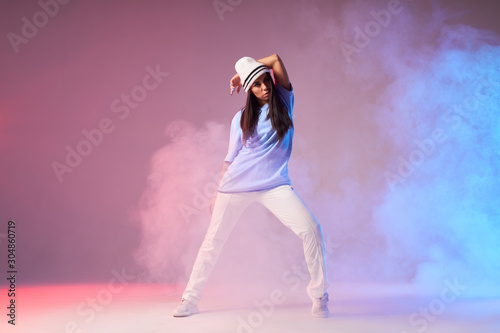 Canvas Print Young pretty hip hop dancer dressed in white pants, blue t shirt with cap dancin