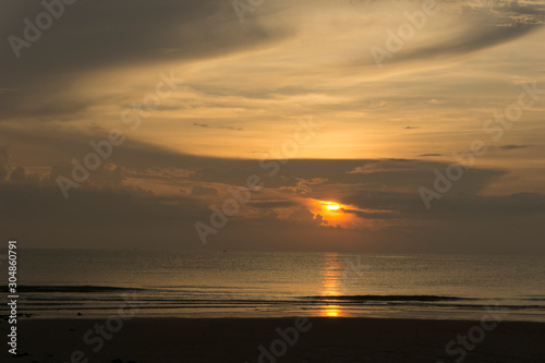 Beautiful dawn, morning sun rises by the sea. Scenic beach, coastline, rocks, cloudscape and skyline photography. Sunrise during the early hours of a summer morning by the beach. Sunset by the beach. © Atthapon