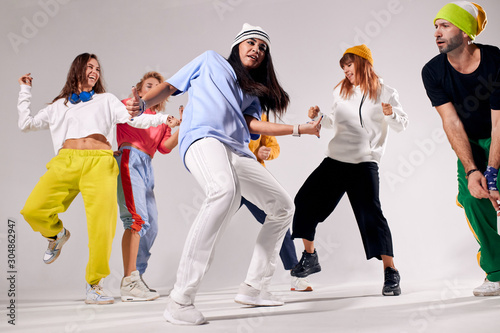 Low angle view of dancing people isolated on white background, having fun, enjoying hip hop party, sport dancing and urban culture concept