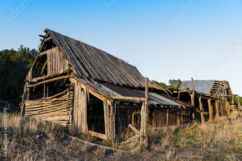Ruins of an old wooden barn made from rustic logs and planks