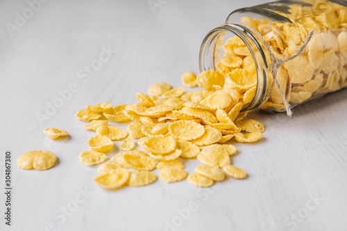 Bild auf Leinwand Corn flakes in a glass jar on white wooden surface