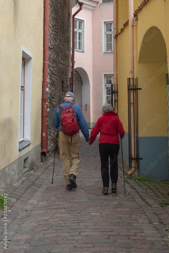 Senior couple walking and holding hands while exploring their travel destination of Old Town Tallin, Estonia