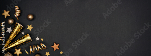 Fotografia New Years Eve corner border banner of glittery gold stars, streamers, decorations and noisemakers