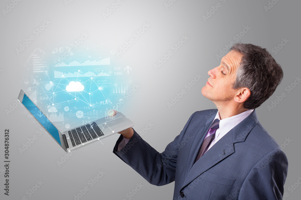 Man holding laptop projecting cloud based system symbols and informations Man holding laptop projecting cloud based system symbols and informations