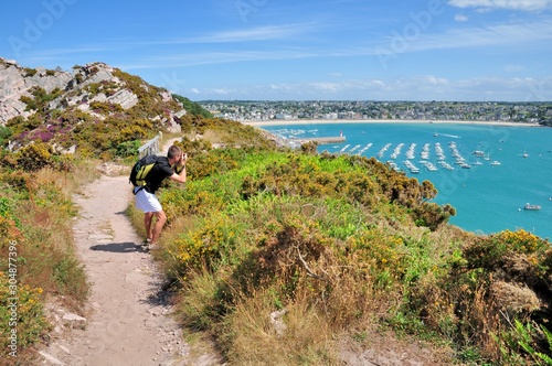 Un homme qui prend une photo sur la côte à Erquy en Bretagne