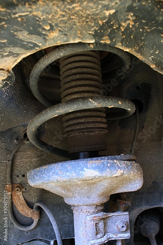 Detail of wheel coil damper spring suspension on 13-years old japanese car photo