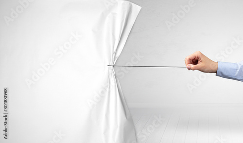 Fotografie hand pulling white paper curtain, changing scene concept