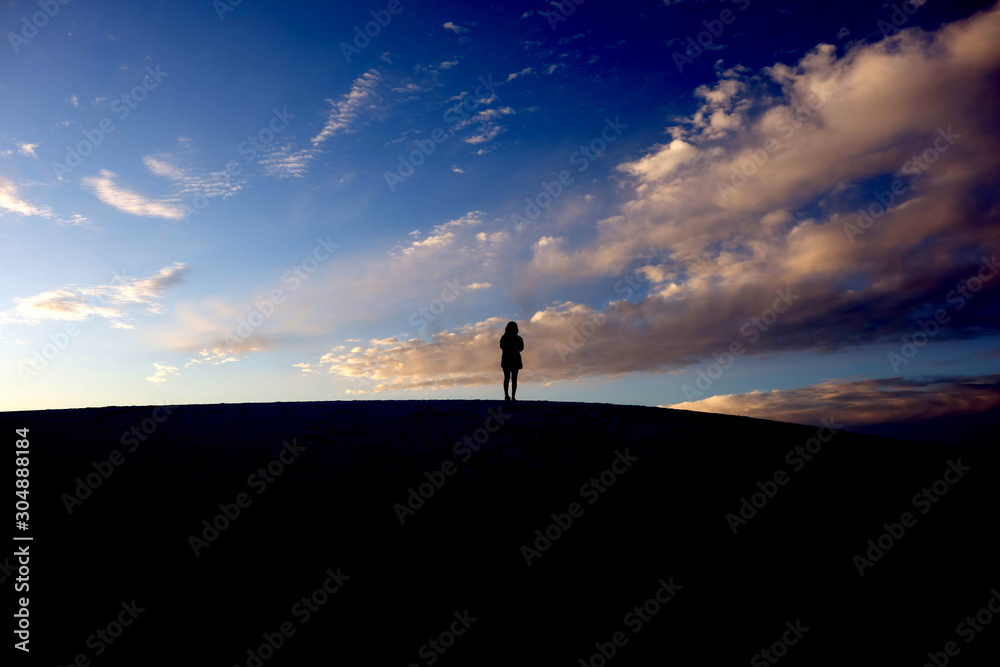 Fototapeta premium silhouette of the woman on the hill on the sky