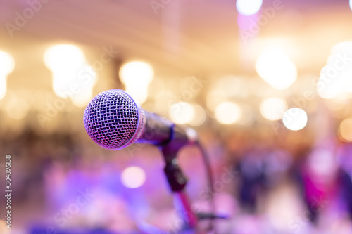 Close up of microphone in concert hall or conference room with light blurred background