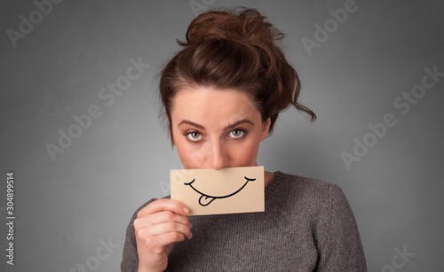 Person with smile card in front of his mouth