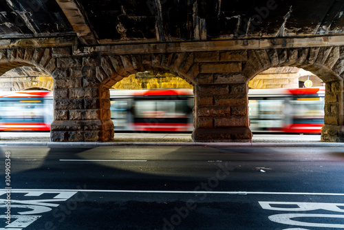 Photography Light rail tram transportation in motion through stone archway