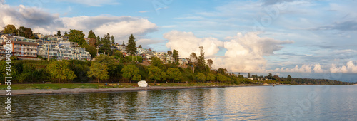 White Rock, British Columbia, Canada. Beautiful Panoramic View of Residential Homes on the Ocean Shore during a sunny and cloudy summer sunset.