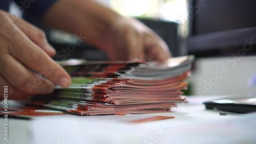 Pile of presentation brochure document concept for Businessman hands working in business Documents on Stacks Brochures papers files for checking achieves reports on busy work computer desk office, 4k