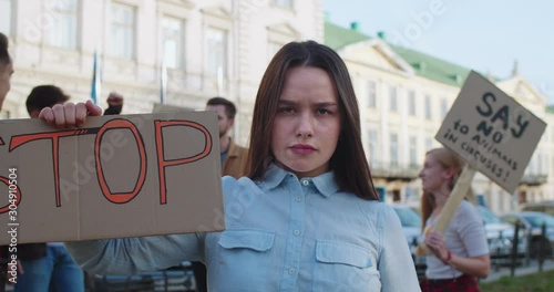 Portrait of the attractive Caucasian young woman protesting in the crowd at the government with a 