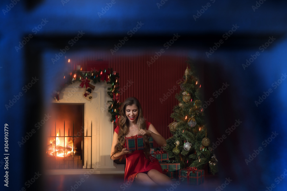 portrait of nice woman in red dress near  christmas tree