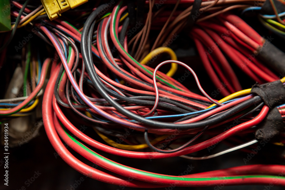 Large wide cable with multicolored red and green wires and connectors and terminals in the wiring repair shop and electricians for connecting and transmitting electricity and digital signals.