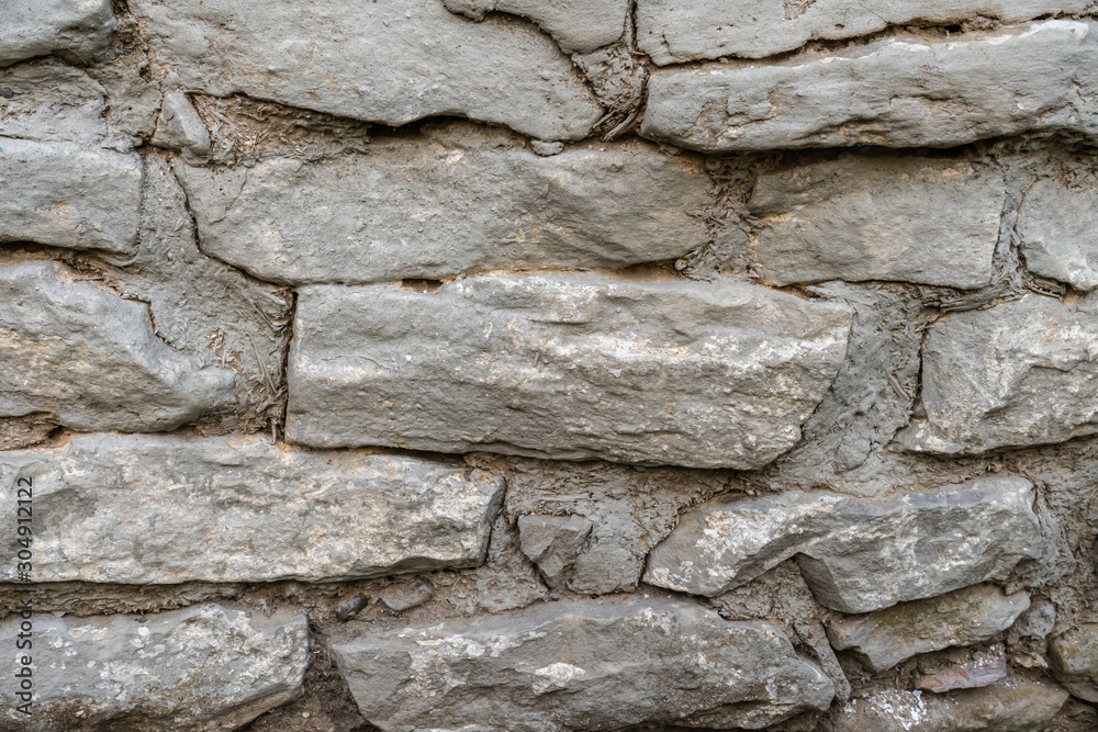 Background of an old wall of stone and clay with straw Background of an old wall of stone and clay with straw