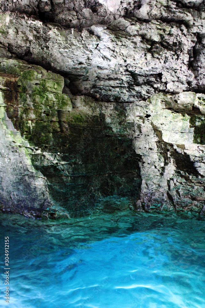 Turquoise water in a grey rock grotto