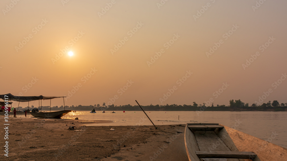 A boat on a sandy beach at sunset A boat on a sandy beach at sunset