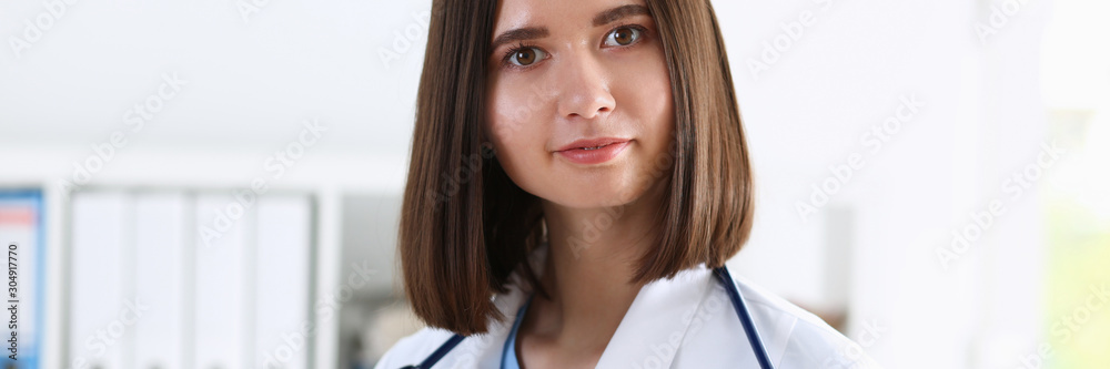 Beautiful smiling female doctor stand in office Beautiful smiling female doctor stand in office