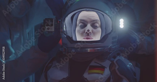 Scientist helping astronaut to put on spacesuit