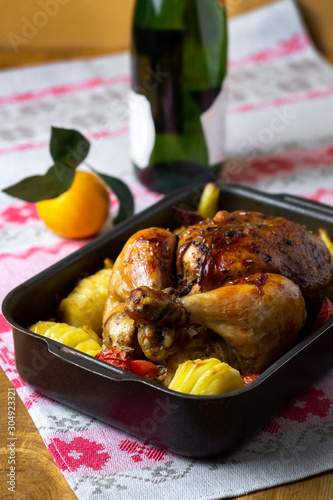 Spicy roasted baked chicken with potatoes. Festive bird baked with vegetables on the table