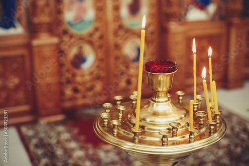 Fotografiet The candle flame in orthodox church, selective focus, closeup
