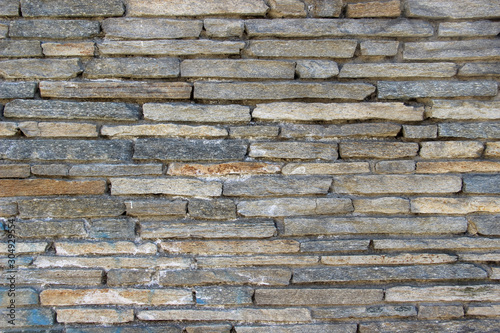 Texture of a wall made of oblong natural stones