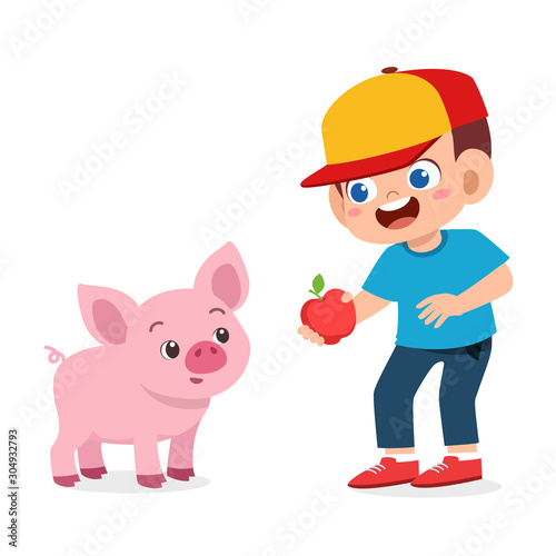 happy cute kid boy feeding cute pig