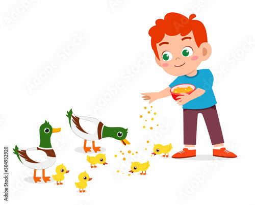 happy cute kid boy feeding cute duck