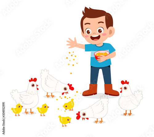 happy cute kid boy feeding cute chicken