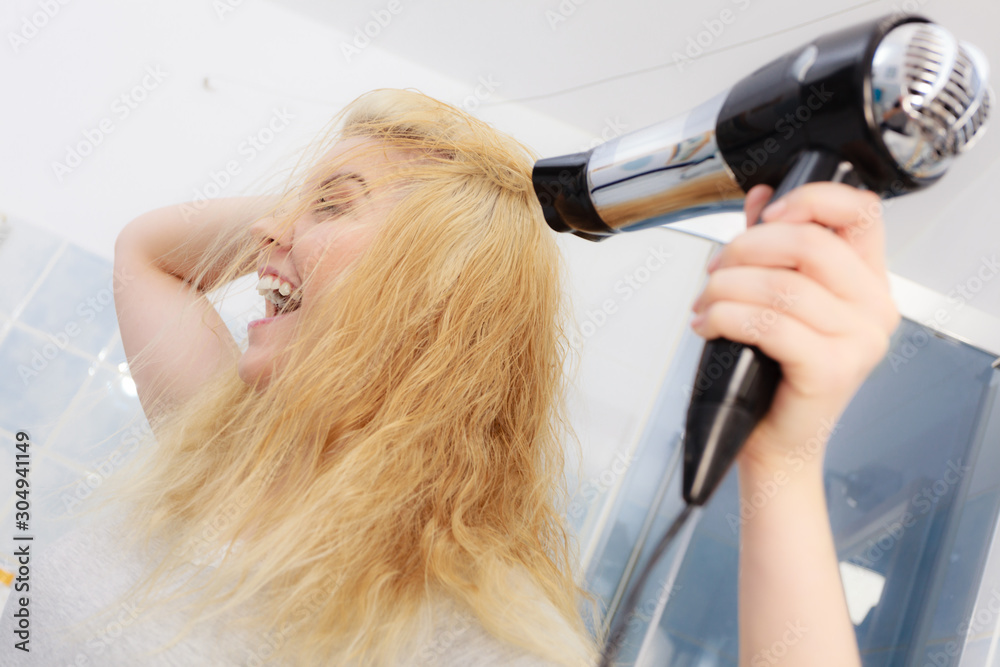 Blonde woman using hair dryer Blonde woman using hair dryer