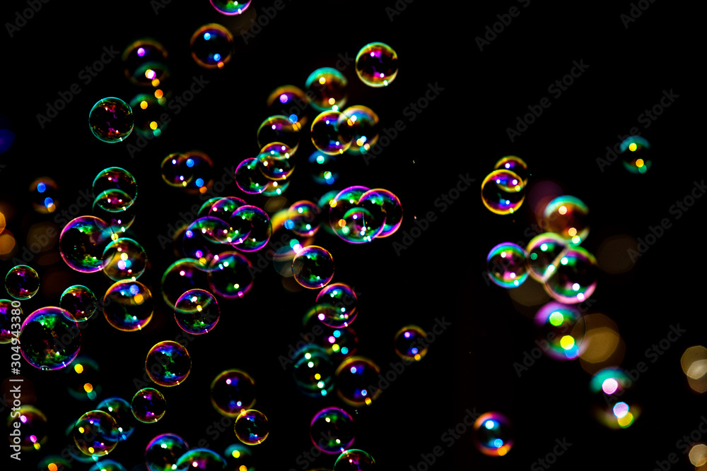 Abstract image of soap bubbles from the bubble blower in dark or black background. Abstract image of soap bubbles from the bubble blower in dark or black background.