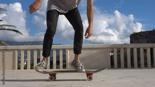 Close up of skater skateboarder man doing 360 kickflip heelflip flip trick in slow motion jump photo