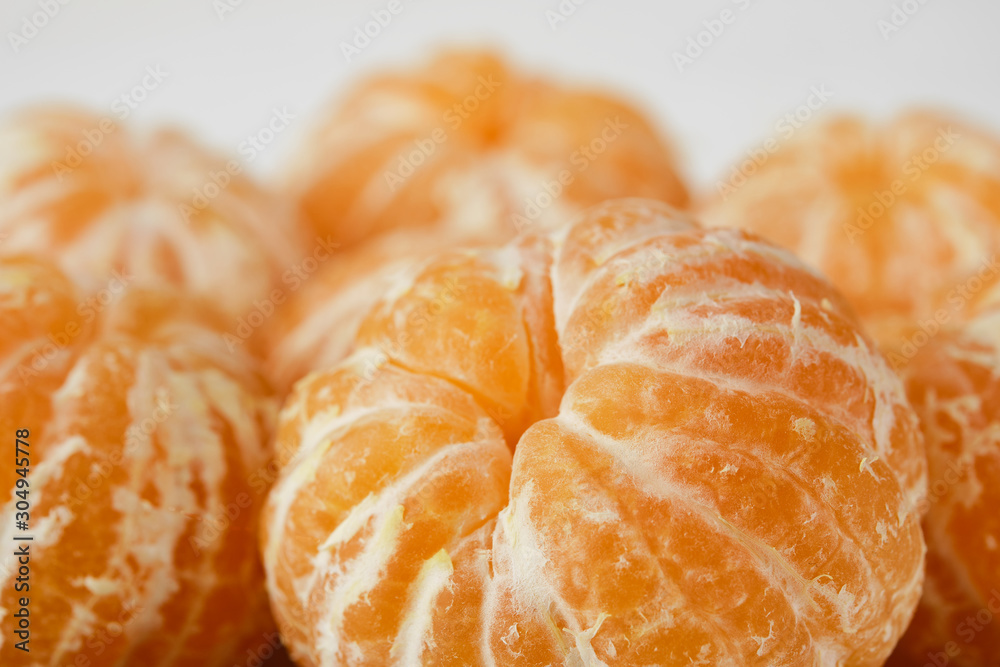sweet and ripe peeled mandarins (tangerines) on white background isolated
