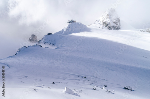 View of a glacier and alpine peaks around Pointe Helbronner and Torino hut above Chamonix and Courmayeur, Mont Blanc Massif, France. The end of a cableway Sky Italia.