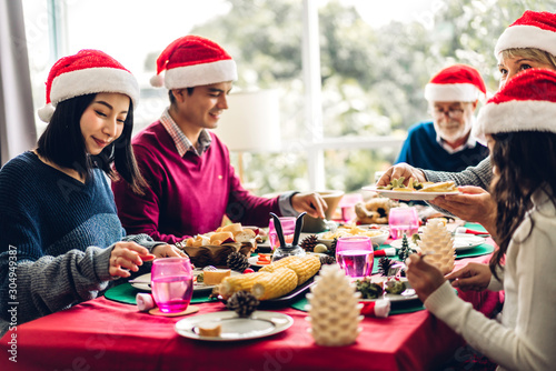 Portrait of happy big family celebrating santa hats having fun and lunch together enjoying spending time together in christmas time at home