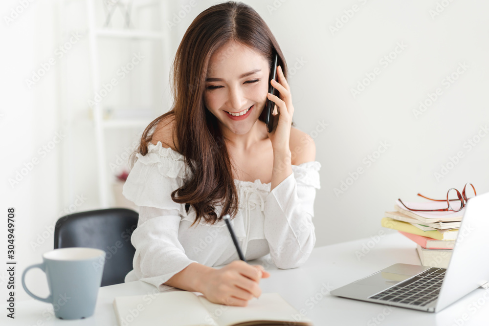 Girl student sitting and studying and learning online with laptop computer and reading a book before the exam at home.education concept Girl student sitting and studying and learning online with laptop computer and reading a book before the exam at home.education concept