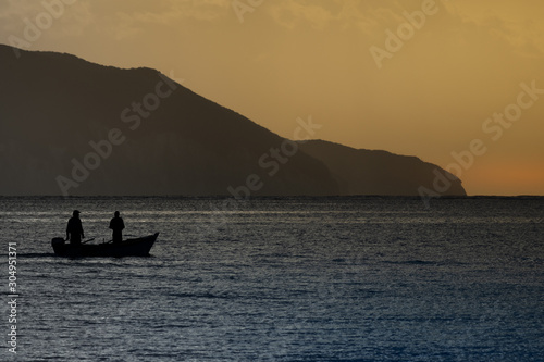 Morning seascape with mountains and fisherman boat