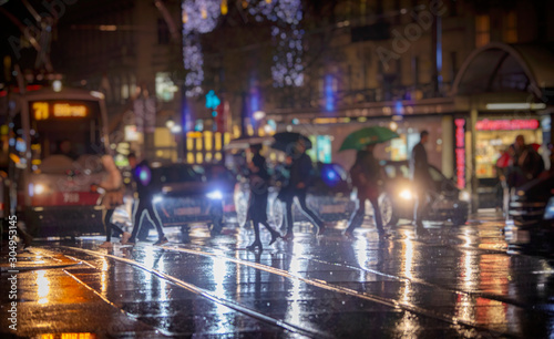 people walking with umbrellas on rainy night in the city
