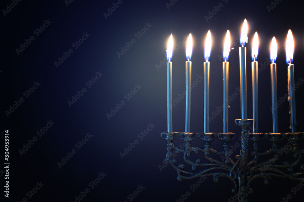 Fototapeta premium Religion image of jewish holiday Hanukkah background with menorah (traditional candelabra) and candles