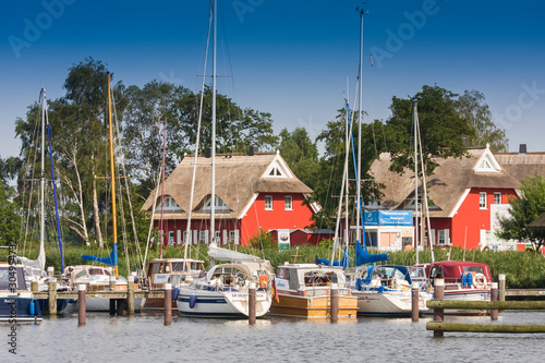 Yachts on the Darss peninsula in the marina of Ahrenshoop-Althagen in front of typical boathouses, Mecklenburg-Western Pomerania, Germany, Europe photo