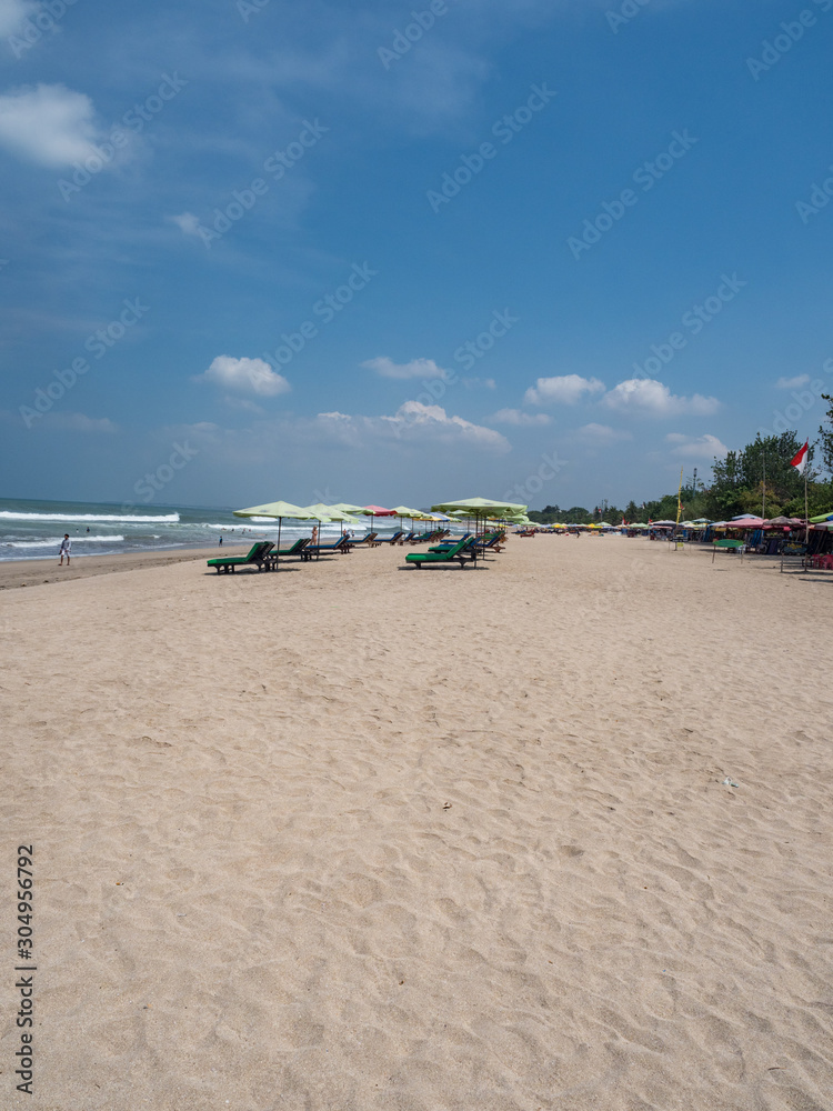 BALI - November 2019: Located on the western side of the island's narrow isthmus, Kuta Beach is Bali's most famous beach resort destination. Autumn in Bali, Indonesia