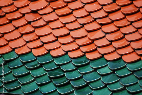 Abstract scene of Brown and green earthenware tiles or calls tiles consists of fish scales on the roof of temple bangkok thailand