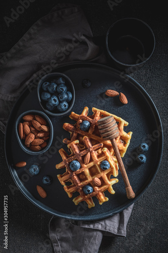 Tasty waffles with honey, almont and blueberries