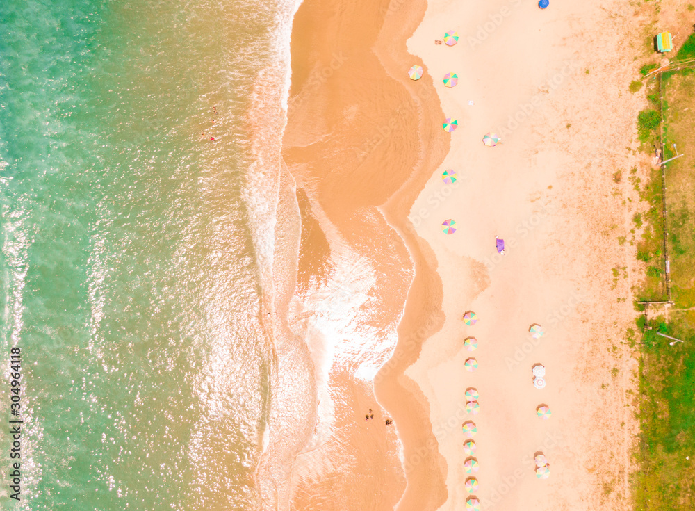 Fototapeta premium Aerial top down beach view with DRONE in Montanita. Dramatic view of the turquoise ocean, orange sand, tourist sunbathers and waves. Shot in Ecuador. Scenic, holiday, tourism shot. Umbrellas and sunbe